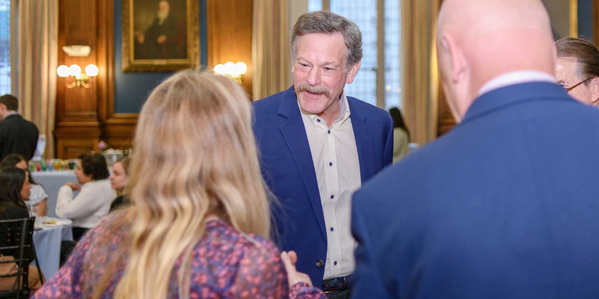 Dr. Kaiser shakes hands with event attendees