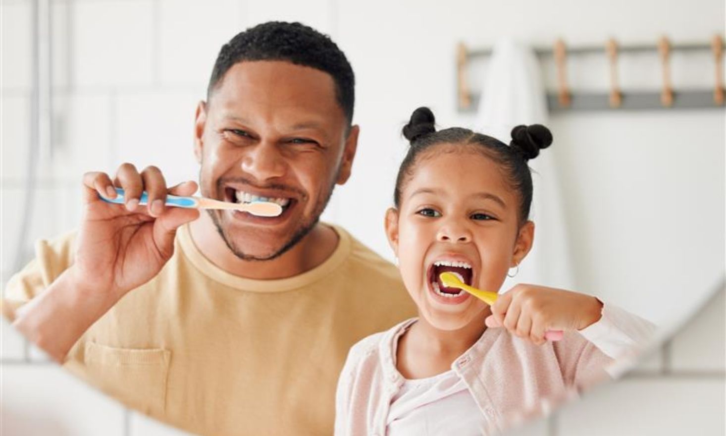 Father and daughter brushing teeth