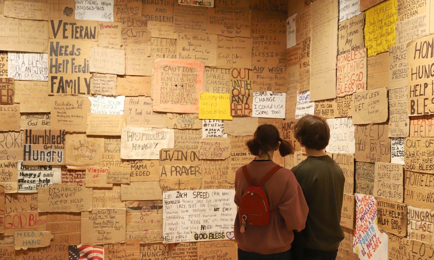 Two people looking at cardboard signs