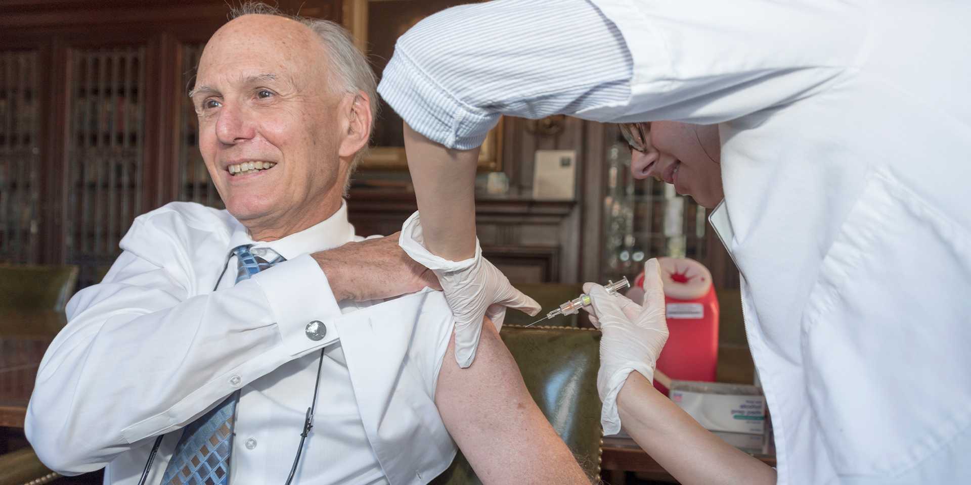 Man with rolled up sleeve receives a vaccine